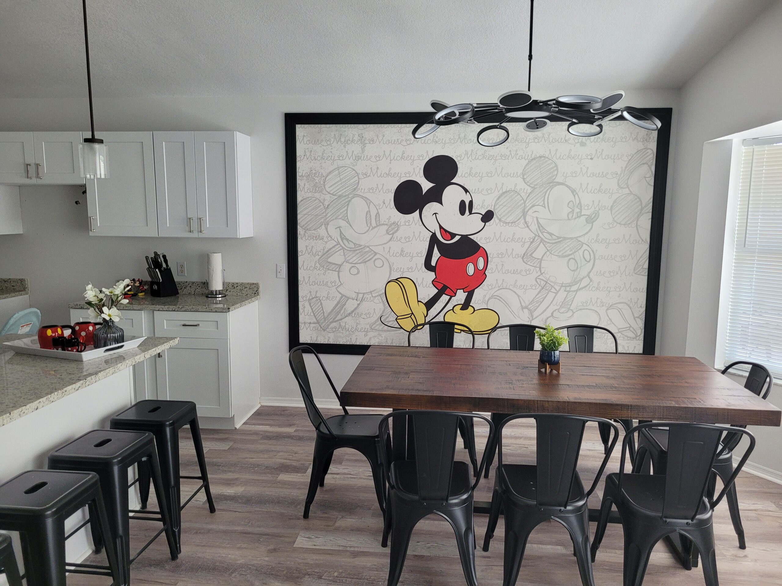 Mickey Mouse themed dining room in an Orlando vacation rental with oversized Mickey mural and black industrial chandelier