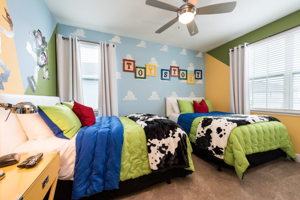 Toy Story themed bedroom in an Orlando vacation rental with cloud wallpaper, Buzz Lightyear mural and TOY STORY letter blocks
