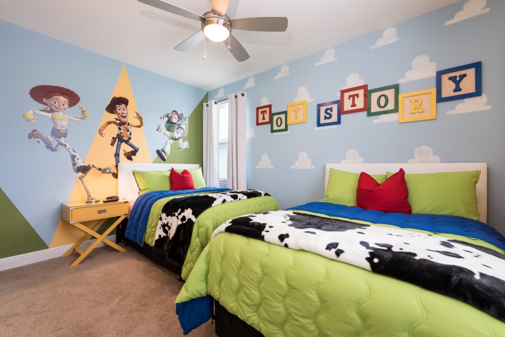Toy Story themed bedroom in an Orlando vacation rental with Jessie, Woody and Buzz mural on a yellow triangle accent wall