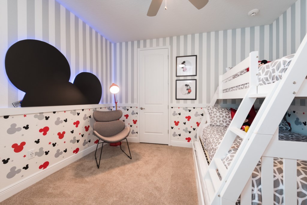 Mickey Mouse themed bedroom in an Orlando vacation rental with an oversized Mickey head cutout glowing blue LED accent