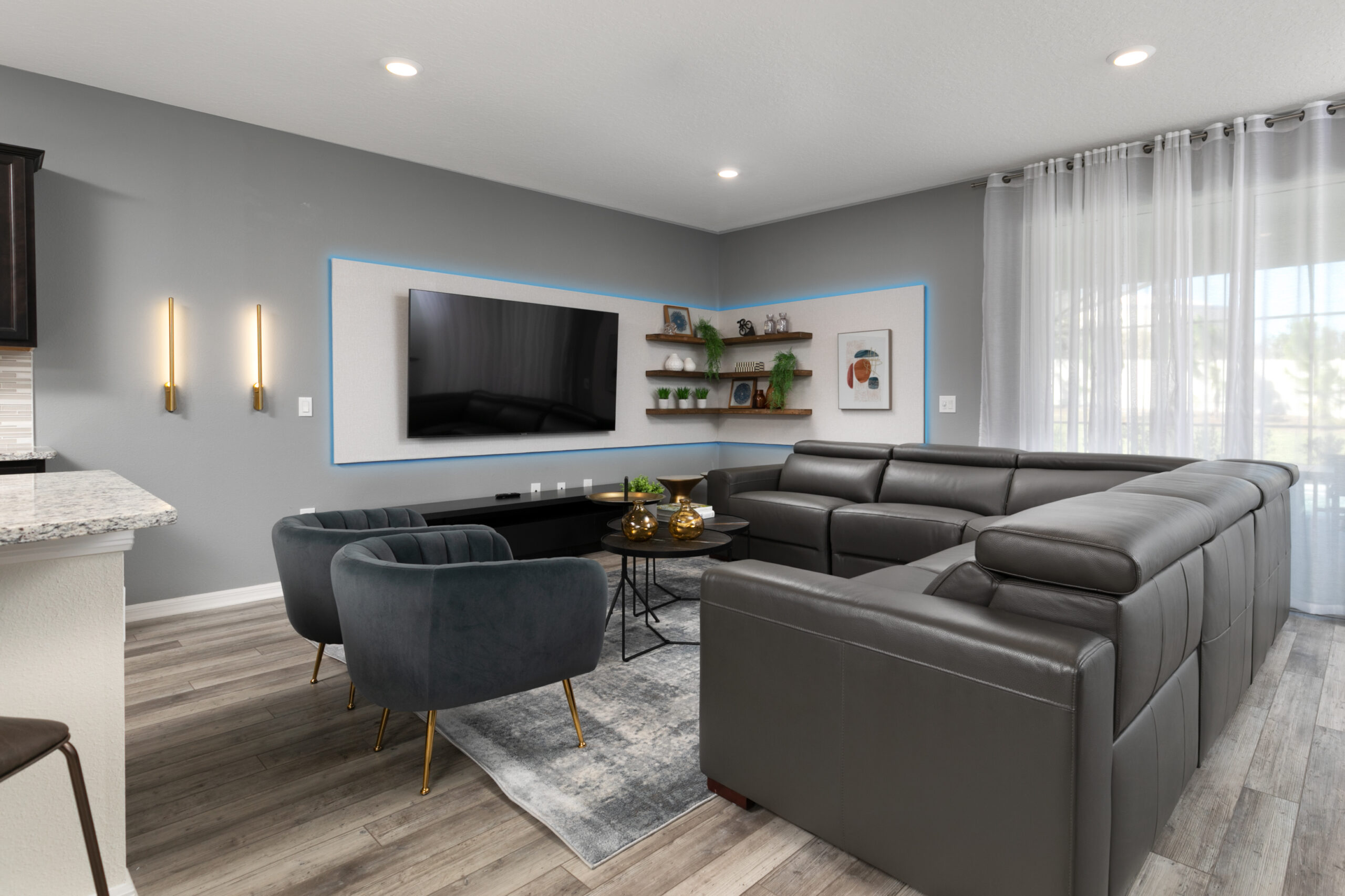 Neutral gray Airbnb living room design in Orlando with leather sectional and brass accents