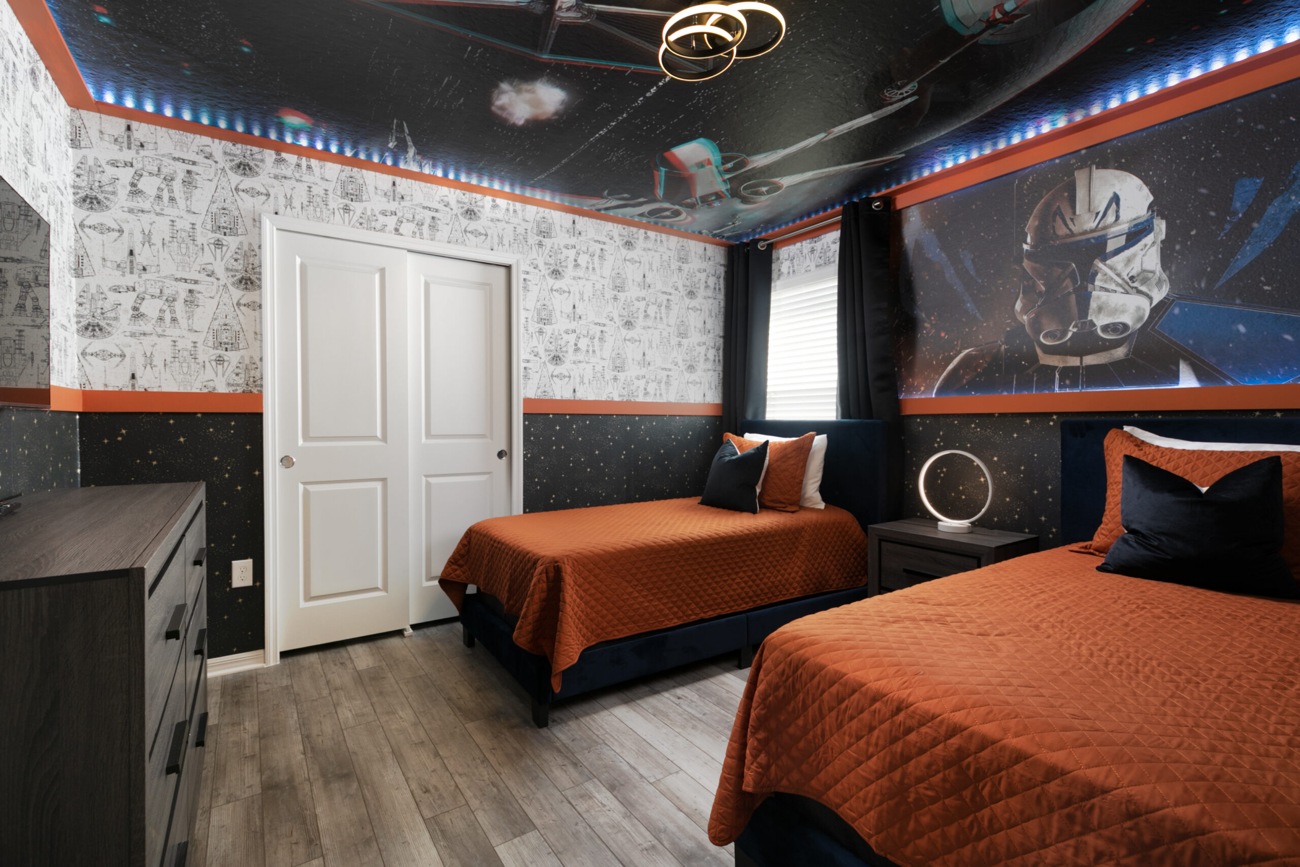 Star Wars themed bedroom in an Orlando vacation rental with starfield ceiling mural, clone trooper wall art and orange bedding