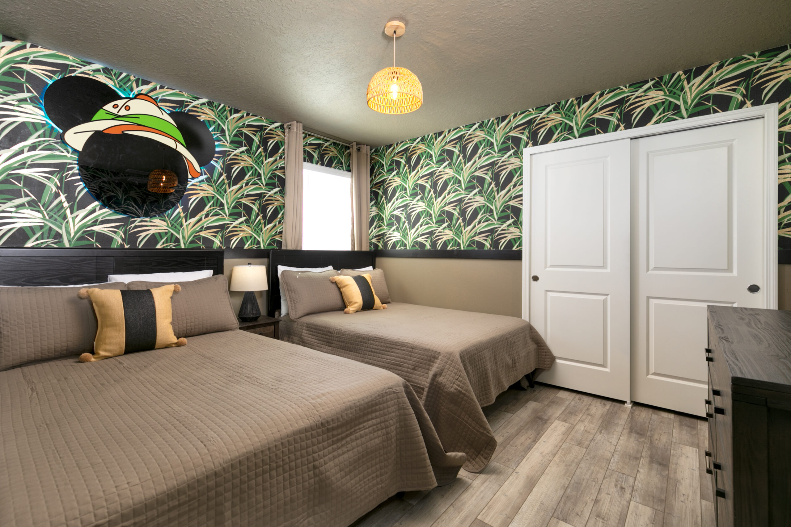 Jungle-print Mickey Mouse themed bedroom in an Orlando vacation rental with black Mickey silhouette accent wall